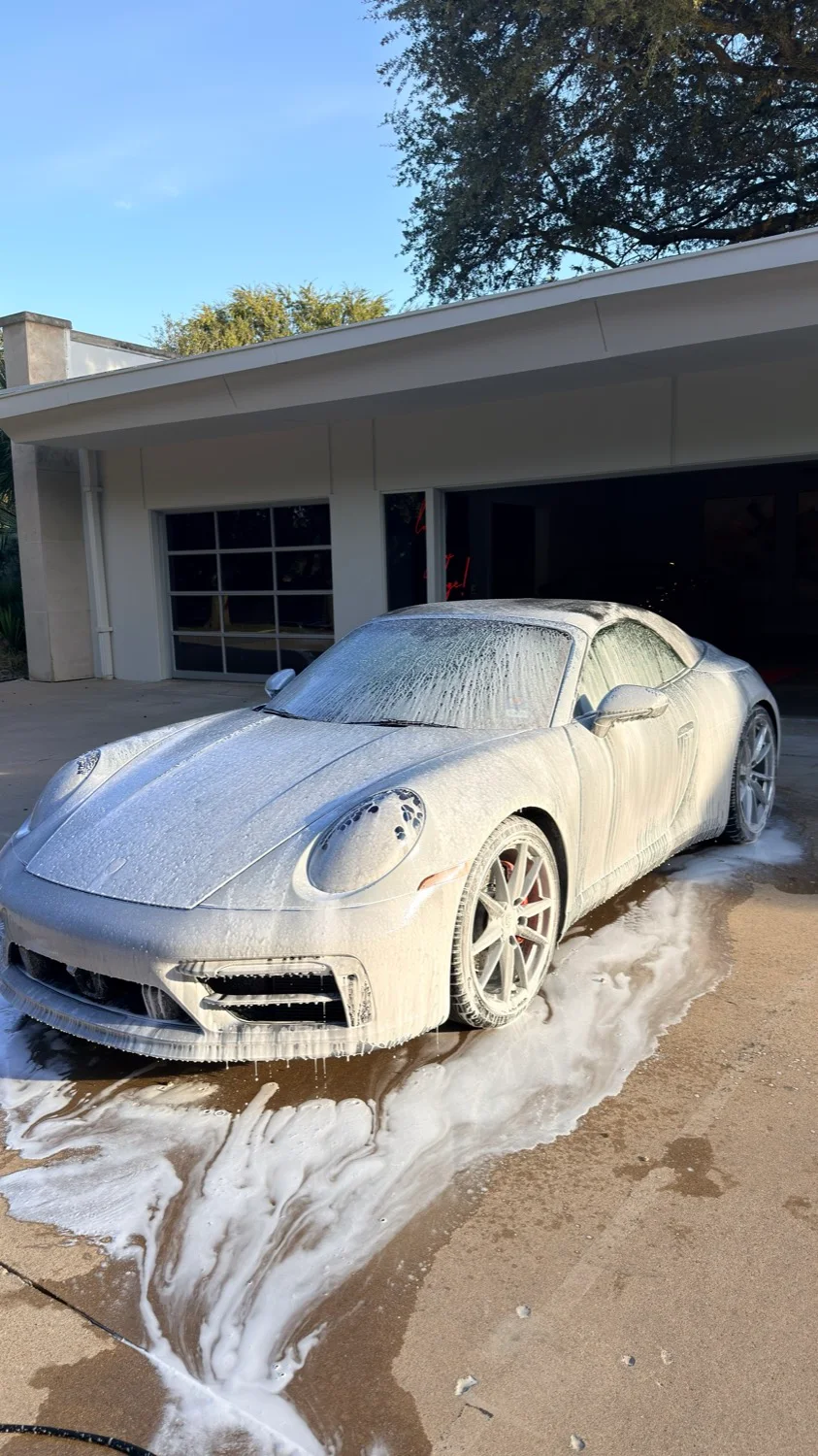 Porsche 911 covered in snow foam during a mobile wash in Dallas